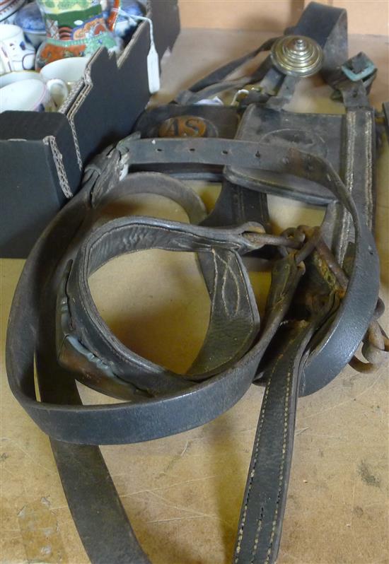 A heavy horse bridle and various farming tools